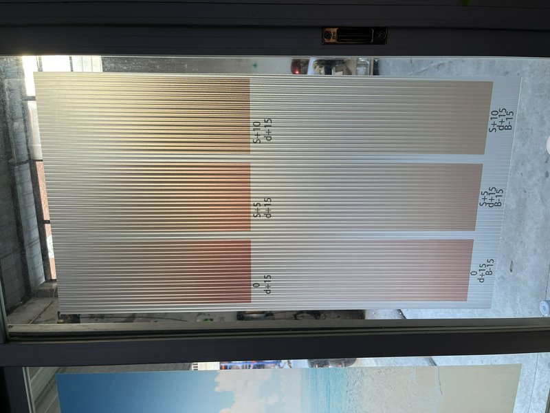 Color swatch panel with vertical striped gradient in beige to brown tones behind a window.