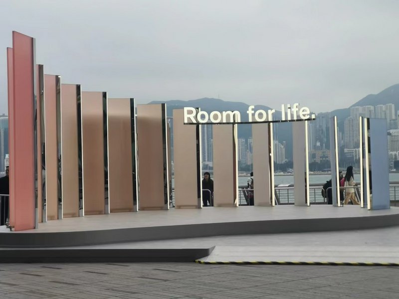 Outdoor public art installation with tall vertical panels and the words “Room for life” overlooki...