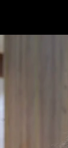 Blurry close-up of vertical wooden paneling in warm brown tones.