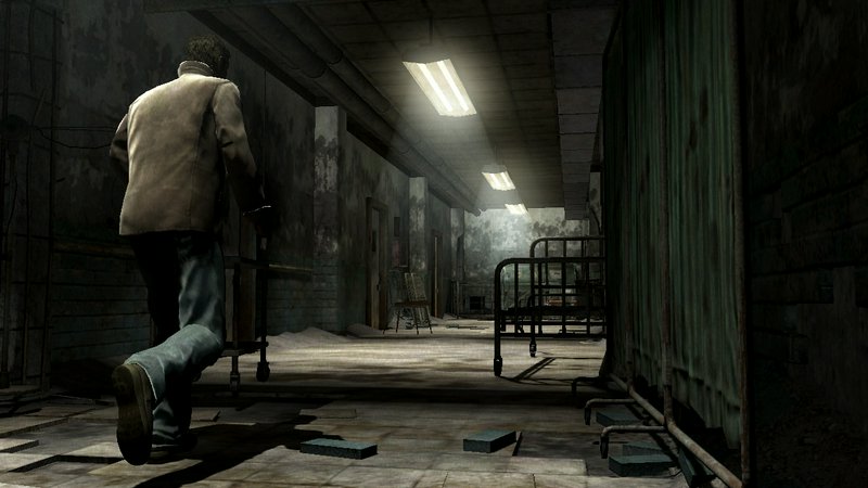 Man in a beige jacket walks down a dim, abandoned hospital corridor with flickering lights.