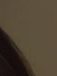 Close-up of a dark brown curved edge against a beige background.