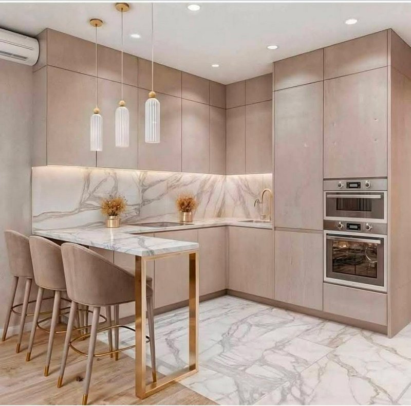 Modern beige kitchen with marble countertops, gold accents, and a marble island with four taupe c...