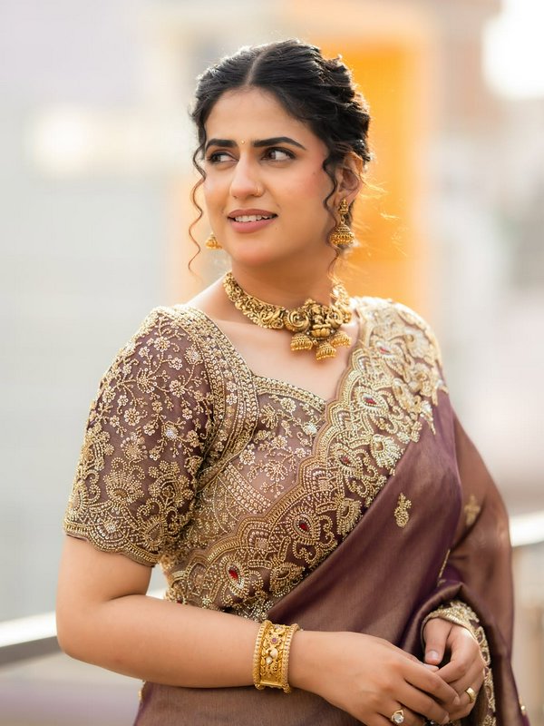 Elegant South Asian woman in a gold-embroidered mauve saree wearing traditional antique gold temp...