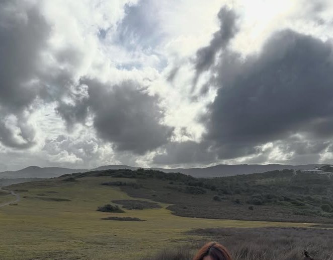 Open moorland with rolling hills under a dramatic, cloud-filled sky