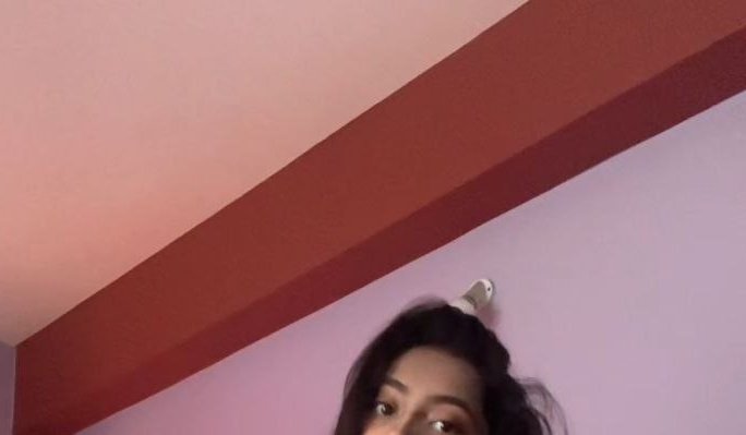 Funny low-angle optical illusion selfie, wall hook appears to be a hair bun holder sitting on a w...
