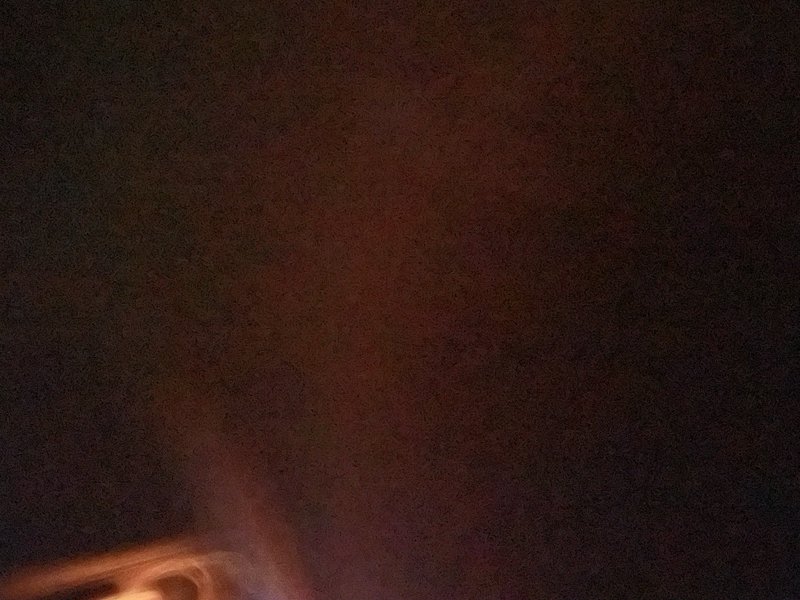 Low-light photo with a warm orange glow at the bottom left corner