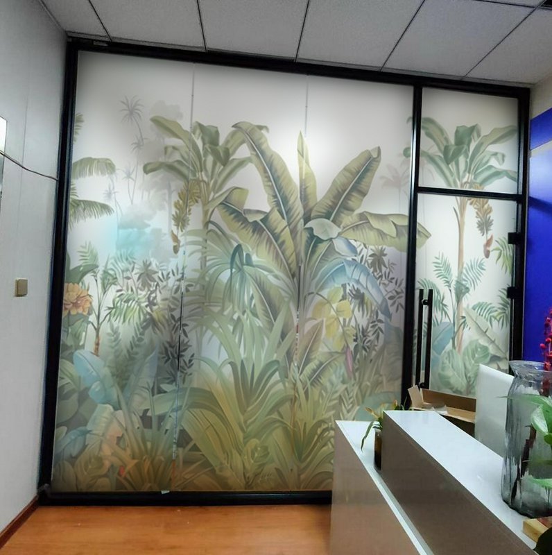 Frosted glass door partition with a tropical jungle plant motif in an office lobby.