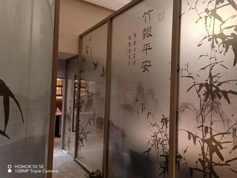 Frosted glass room dividers with bamboo artwork and Chinese calligraphy in an interior