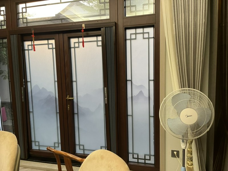 Interior with dark wood-framed frosted glass doors showing mountain silhouettes and lattice patterns