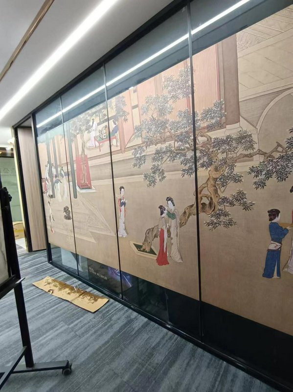 Large traditional Chinese mural behind glass panels in a modern hallway.