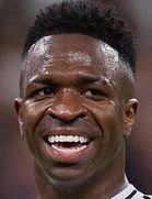 Close-up of a smiling male athlete with sweaty skin and short hair.