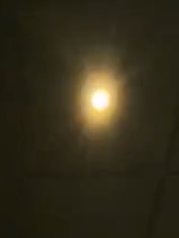 Blurry bright light in a dark setting with a soft halo and hazy glow