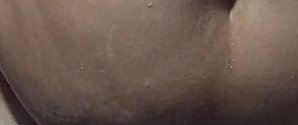 Macro close-up of warm toned human skin dotted with small clear sweat beads, adjacent to a natura...