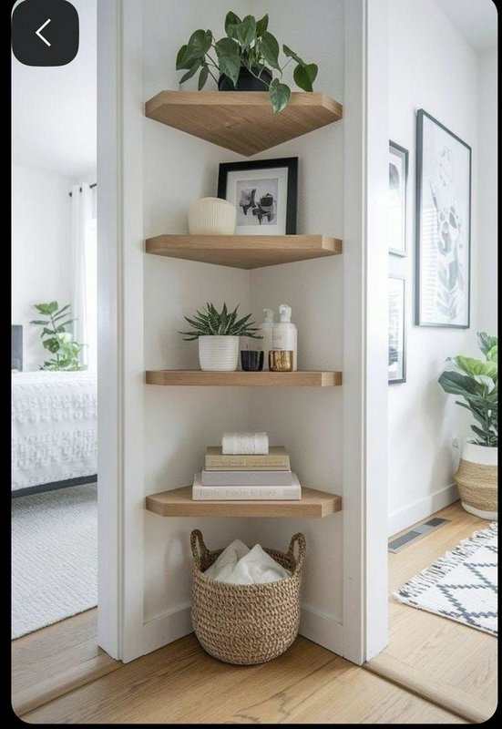 Corner shelf with wooden floating shelves, greenery, and a woven basket at the base.