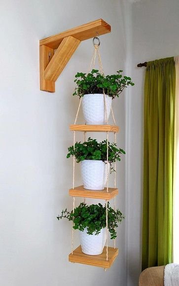 Wooden four-tier hanging planter with white pots and trailing green plants indoors