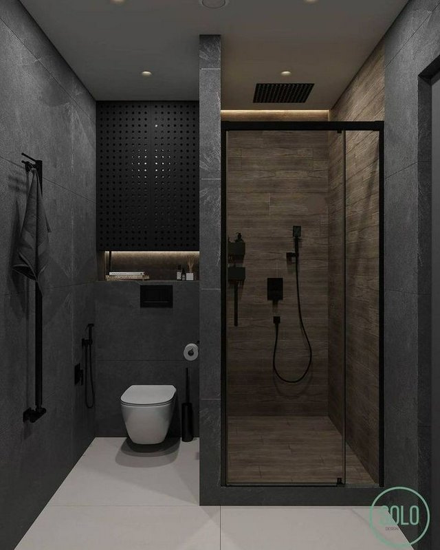 Dark minimalist modern bathroom with wall-mounted toilet, glass walk-in shower, matte black fixtu...