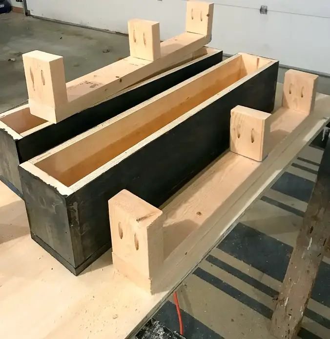 Woodworking jig components with unintentional silly cartoon faces from pocket holes sit on a gara...