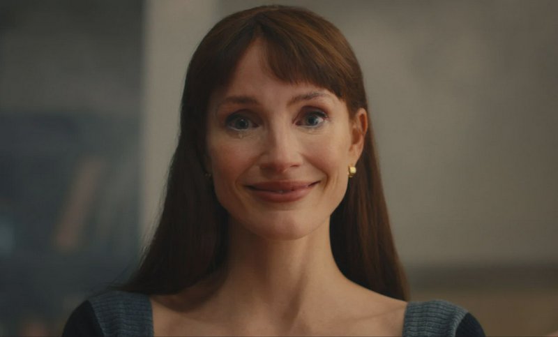 Close-up portrait of Jessica Chastain with a tearful soft smile, long brown hair with bangs, agai...