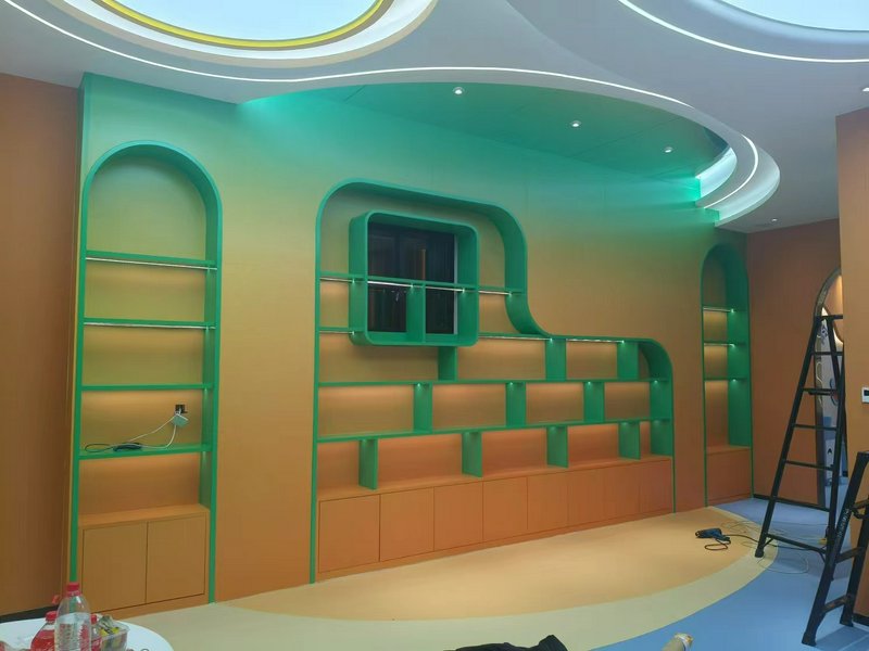 Modern interior with green curved shelving and orange walls.