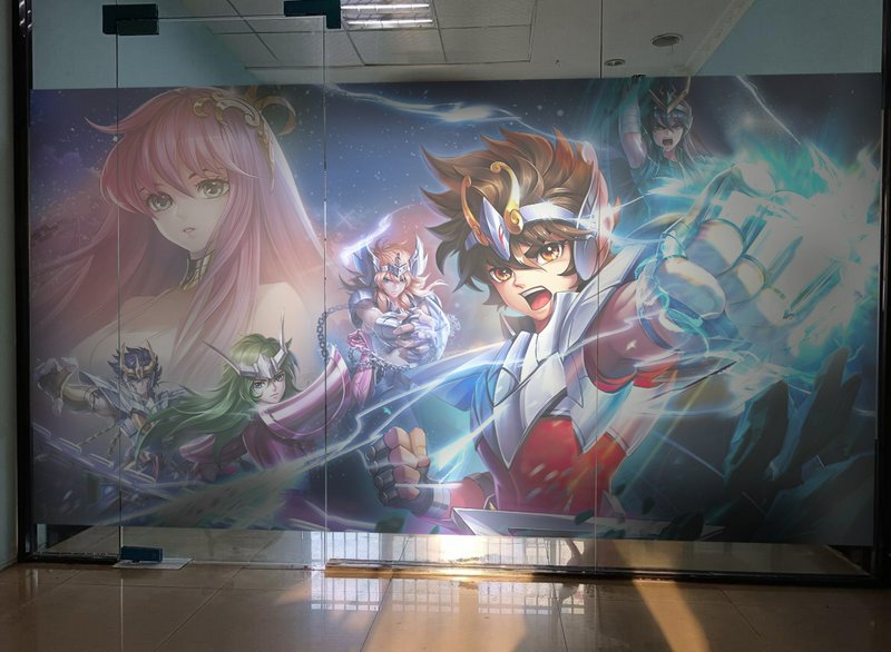 Large anime-style mural on glass wall featuring dynamic heroic characters in action.