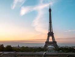 Paris: silhouette of the Eiffel Tower at sunset over the city skyline.