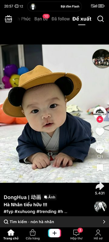 Screenshot of a TikTok showing an adorable baby wearing a novelty panda ear cosplay hat lying on ...