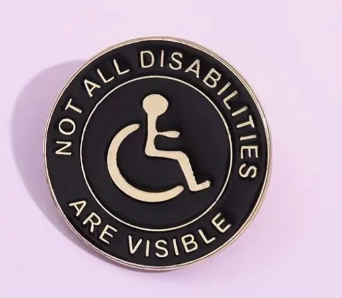 Black and gold enamel lapel pin reading "Not All Disabilities Are Visible" with a wheelchair symb...