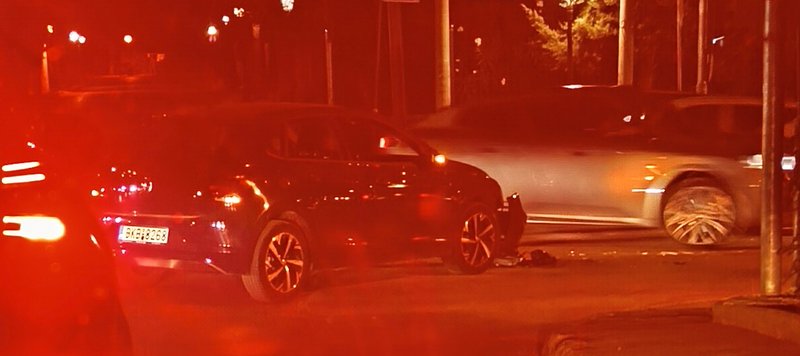 Nighttime car crash scene illuminated by red emergency lights, with damaged SUV and silver sedan ...