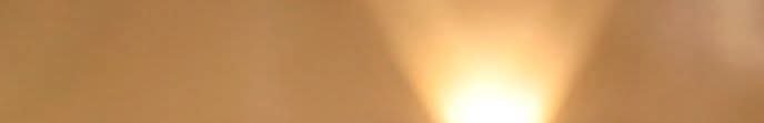 Close-up of a warm golden light flare with soft, glowing amber tones