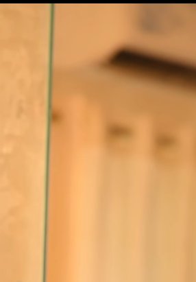 Close-up of a glass edge with a warm, softly blurred background