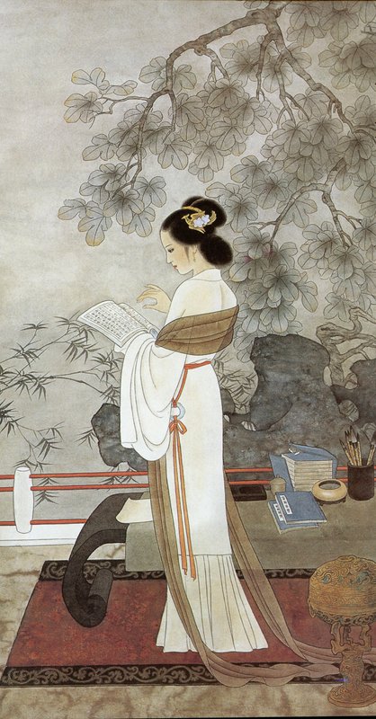 Elegant woman in a white traditional dress reading a book under a flowering tree in a classical C...
