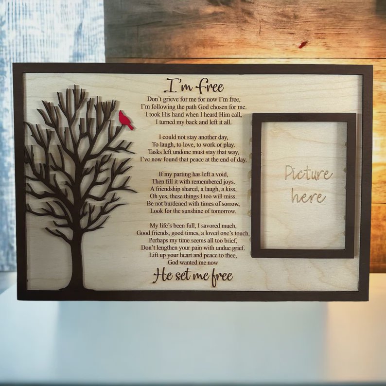 Wooden wall art with a carved tree, the "I'm free" poem, and an empty photo frame on the right.