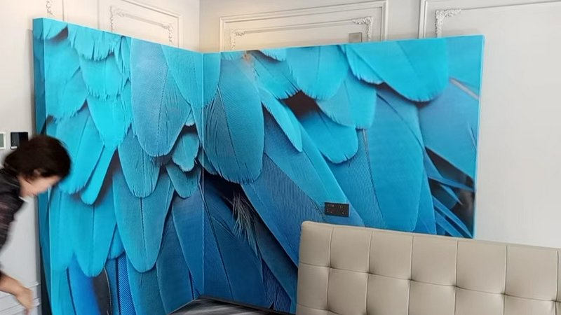 Blue feather-pattern wall panels forming a decorative room divider in a modern interior.