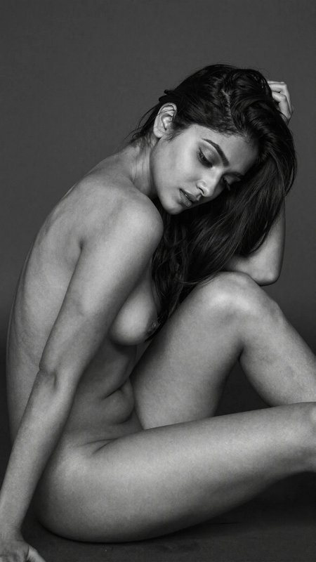 Artistic black-and-white nude portrait of a seated woman with bowed head.