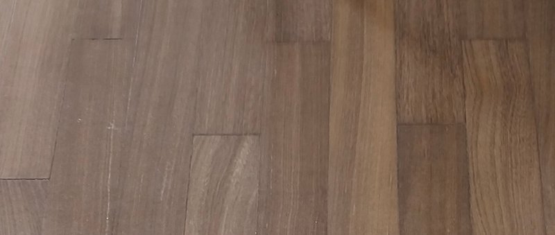 Close-up top view of staggered warm taupe-brown hardwood plank flooring with visible natural wood grain texture.