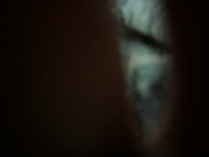 Abstract night photo with a narrow, blurred vertical light stripe on the right side against a dark background