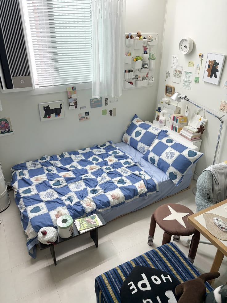 Cozy sunlit small bedroom with blue checkered heart print bedding and playful cute decor accents
