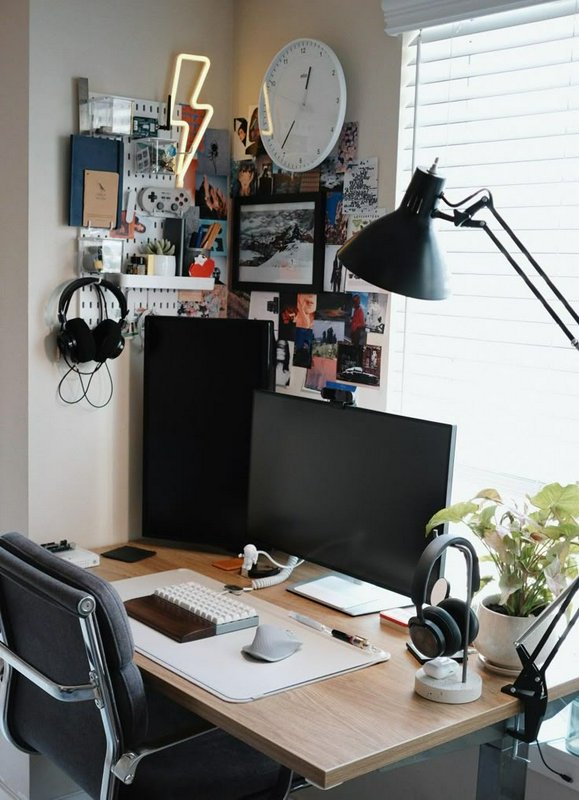 Cozy aesthetic home office desk setup with dual monitors, wall pegboard organizer, neon decor, an...