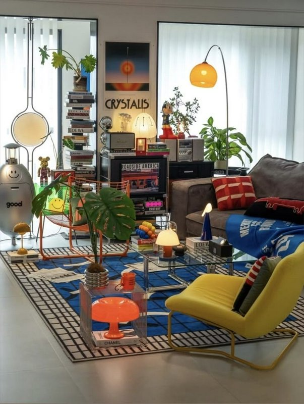 Bright eclectic retro maximalist living room filled with colorful furniture, houseplants, and pla...