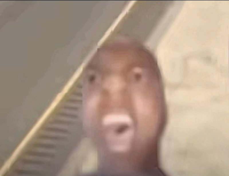 Blurry close-up of a man with mouth open, captured by a low-quality camera.