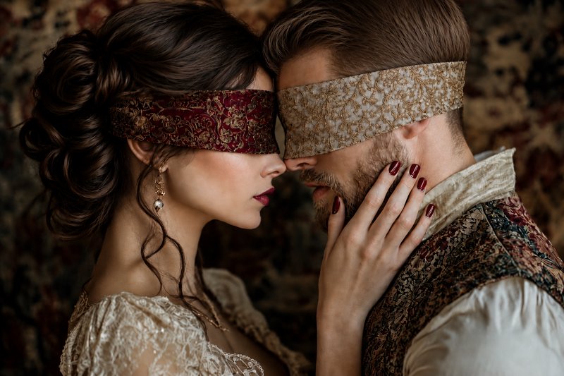 [Close-up intimate portrait of blindfolded vintage couple touching foreheads, woman resting hand gently on man's face agai...