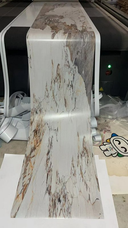 Long roll of marble-pattern vinyl/wallpaper fed through a large-format printer, white with brown ...