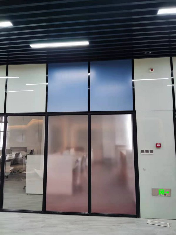 Glass-walled office entrance with frosted gradient doors and blue panels in a modern corporate lobby