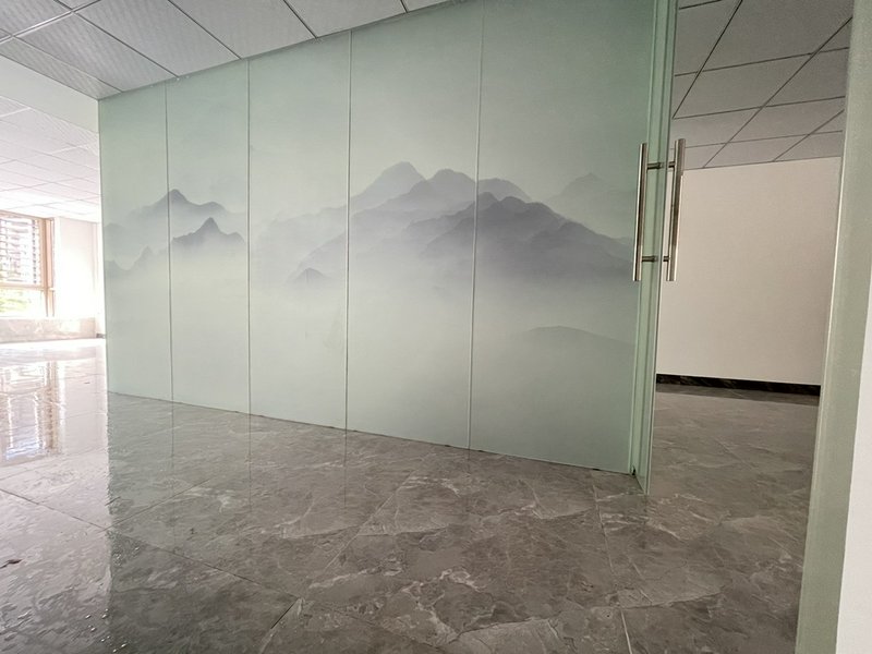 Frosted glass wall with a subtle mountain mural in a modern office interior.