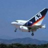 Commercial A3 passenger jet with extended landing gear flies low, set against a clear blue sky an...