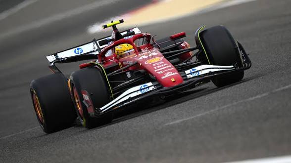 Red Ferrari Formula 1 race car speeding on a track with front wing and large tires in motion