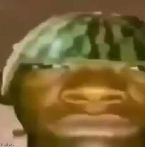 Close-up of a person wearing a green camouflage helmet with a blurred, amused facial expression.