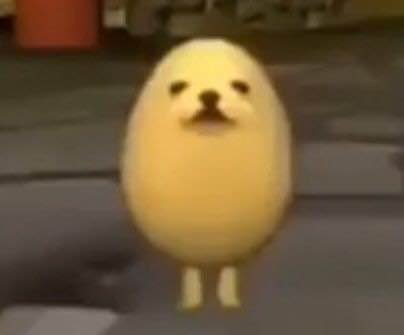Cute yellow chick with small legs standing on a street background.