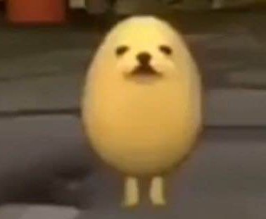 Cute yellow oval chick-like character with tiny feet standing on a pavement.