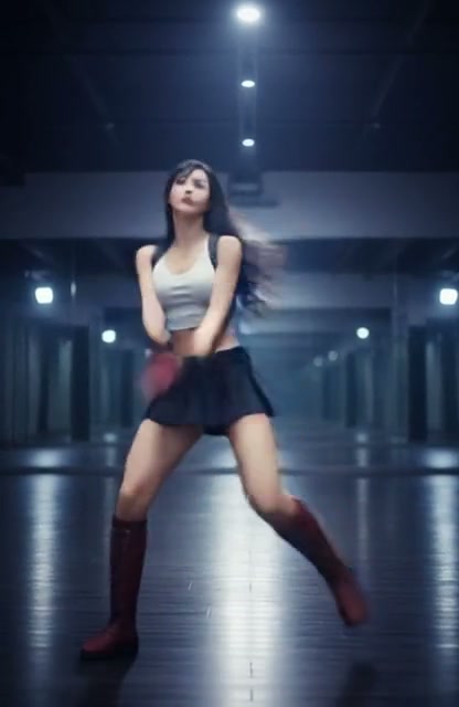 Young female dancer mid energetic move, motion blurred, in a dim mirrored dance studio in casual ...